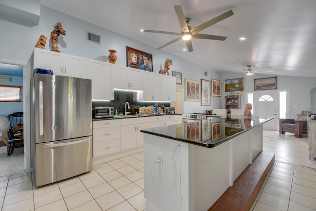 kitchen with sink, stainless steel appliances, white cabinets, and light tile patterned flooring