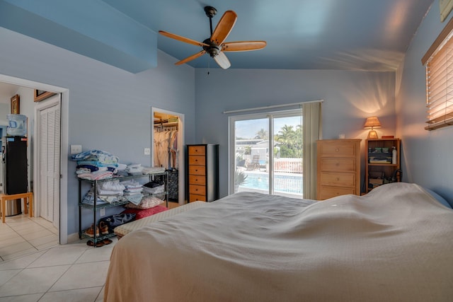 bedroom featuring a walk in closet, light tile patterned floors, lofted ceiling, and ceiling fan