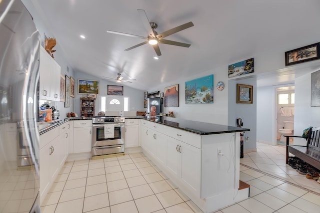 kitchen with appliances with stainless steel finishes, kitchen peninsula, light tile patterned floors, and white cabinets