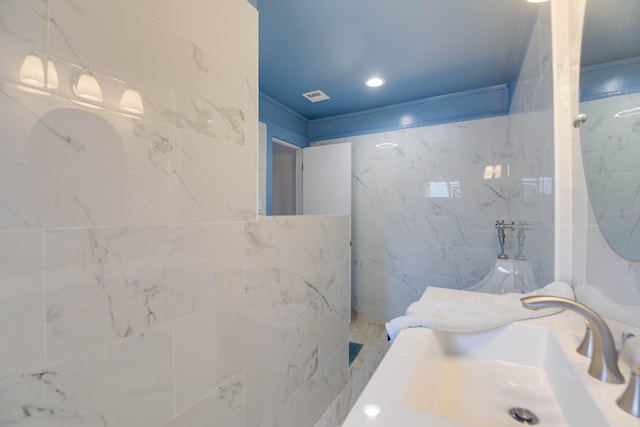 bathroom with sink, tile walls, and a shower