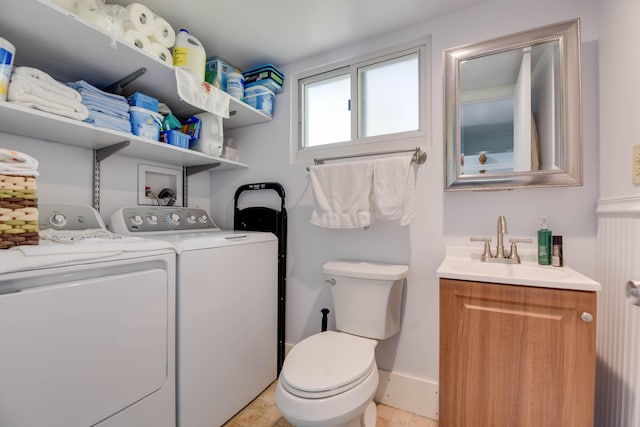 bathroom featuring vanity, toilet, and washing machine and dryer