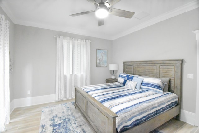 bedroom featuring ornamental molding, baseboards, light wood-style flooring, and a ceiling fan