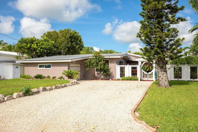 view of front of property with driveway, a front lawn, and stucco siding