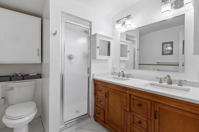 bathroom with double vanity, a sink, toilet, and a shower stall