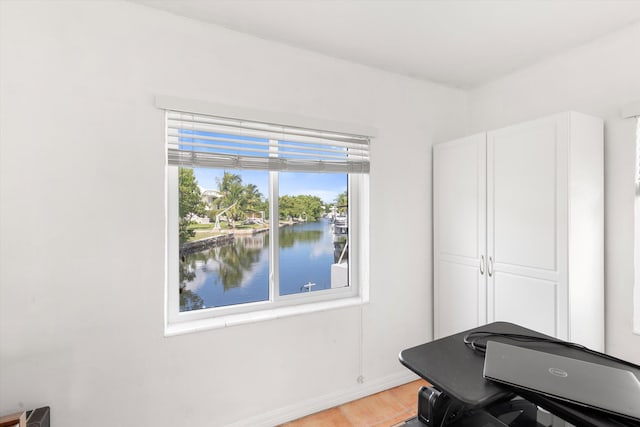 home office featuring a water view and light wood-style flooring