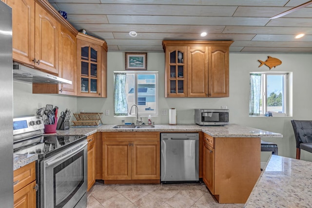 kitchen with appliances with stainless steel finishes, sink, kitchen peninsula, light stone countertops, and wooden ceiling