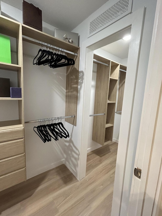 spacious closet with hardwood / wood-style flooring