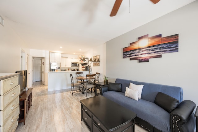 living area with a ceiling fan, recessed lighting, and light wood finished floors