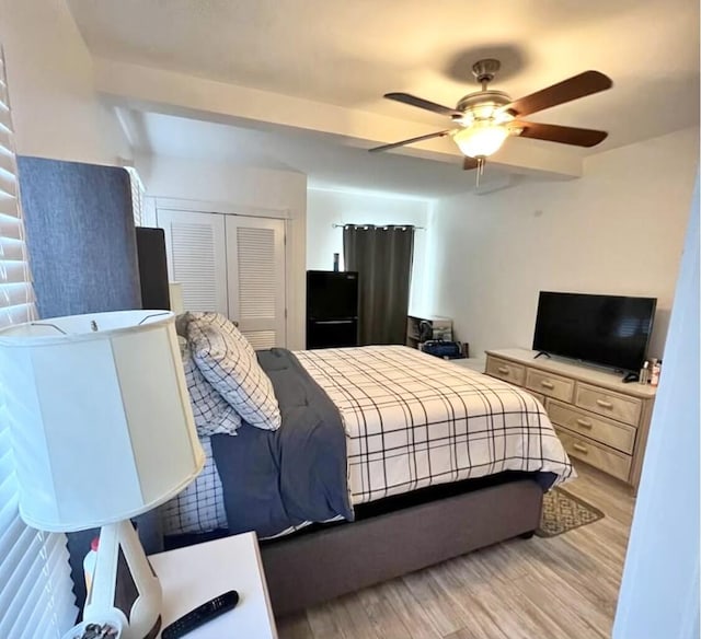 bedroom featuring a ceiling fan, light wood-type flooring, and a closet