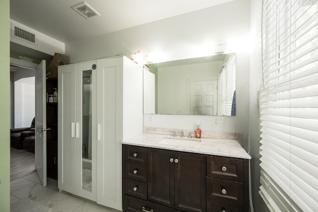 bathroom with marble finish floor, vanity, and visible vents