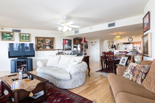 living room featuring ceiling fan and light hardwood / wood-style flooring