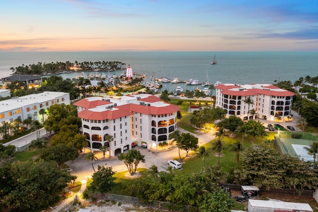 aerial view at dusk featuring a water view