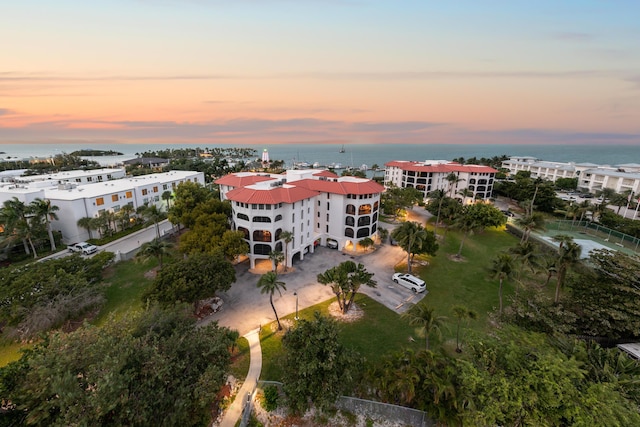 aerial view at dusk featuring a water view