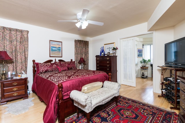 bedroom with ceiling fan, a textured ceiling, and light wood-type flooring