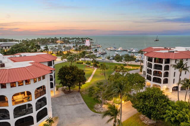 aerial view at dusk featuring a water view