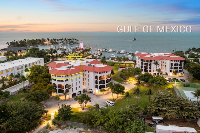 aerial view at dusk featuring a water view