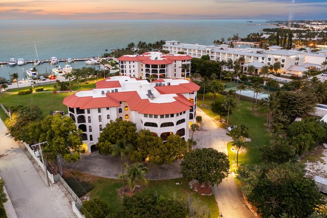 aerial view at dusk featuring a water view