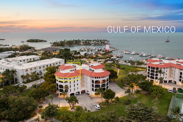 aerial view at dusk featuring a water view