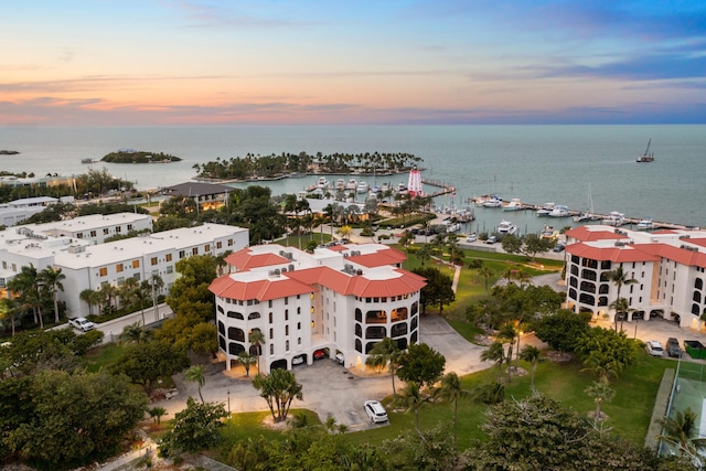 aerial view at dusk featuring a water view