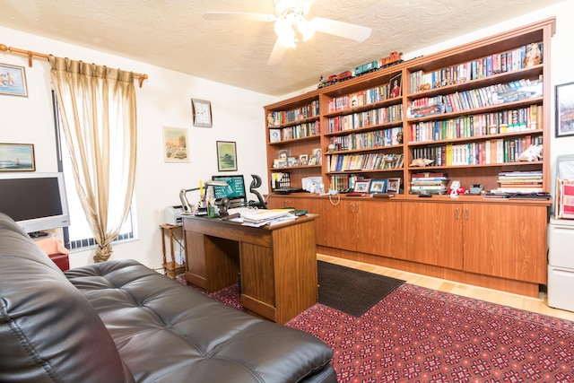 home office with ceiling fan, a textured ceiling, and light hardwood / wood-style flooring