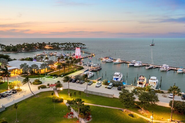 aerial view at dusk featuring a water view