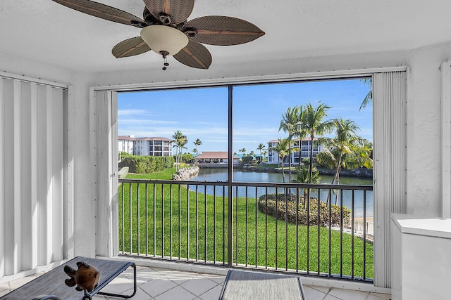 sunroom / solarium with a water view and ceiling fan