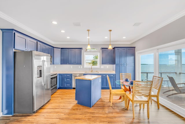 1777 Pine Channel Dr, Little Torch, FL 33042 - kitchen with appliances with stainless steel finishes, light countertops, ornamental molding, light wood-style floors, and a center island