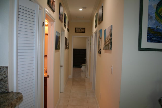 hall with ornamental molding and light tile patterned floors