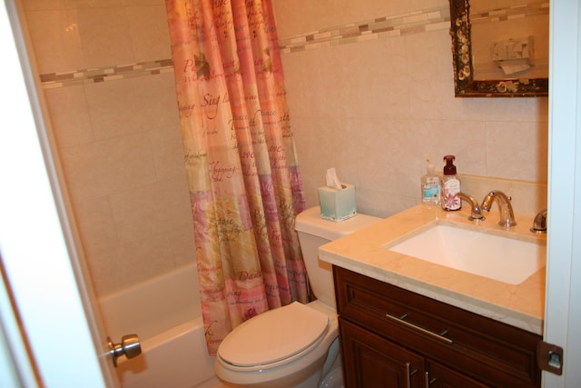 full bathroom with vanity, tile walls, shower / tub combo with curtain, and toilet