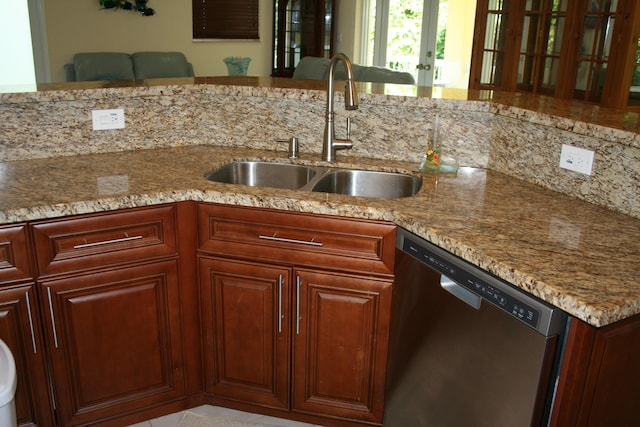 kitchen featuring sink, stainless steel dishwasher, kitchen peninsula, and light stone countertops