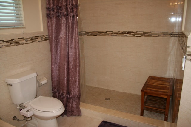 bathroom featuring tile walls, tile patterned flooring, curtained shower, and toilet