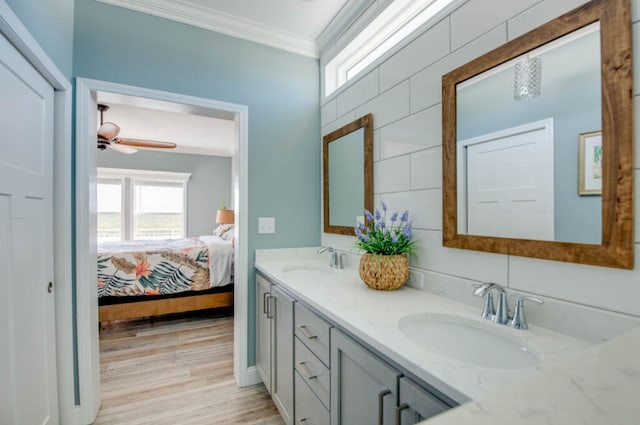 bathroom with vanity, hardwood / wood-style flooring, ornamental molding, and ceiling fan