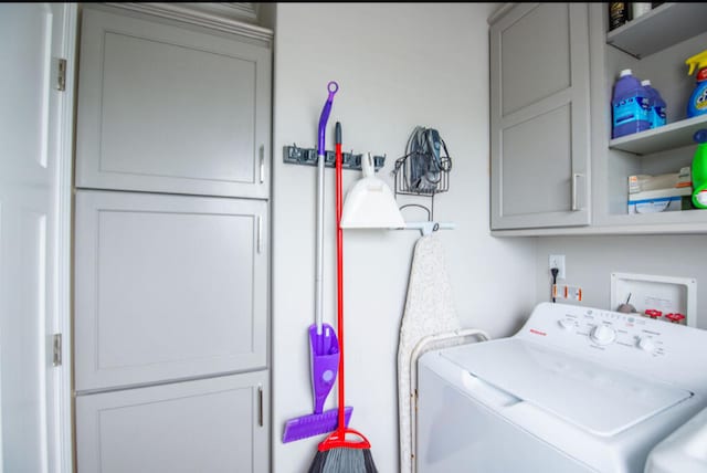 washroom with cabinets and washer / clothes dryer