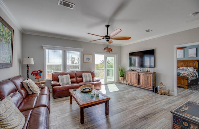 living room featuring ornamental molding, ceiling fan, and light wood-type flooring