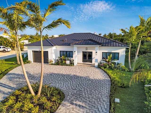 view of front of house with a standing seam roof, metal roof, decorative driveway, and a garage