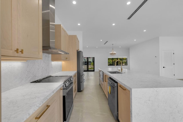kitchen with wall chimney range hood, stainless steel appliances, recessed lighting, and a sink