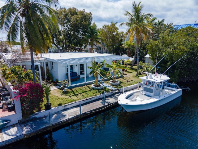 back of property featuring a patio, a yard, and a water view