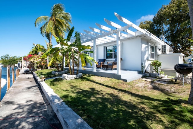 back of house featuring stucco siding, a lawn, and a pergola