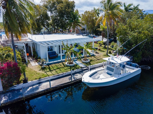 back of property with a yard, a water view, and a patio area