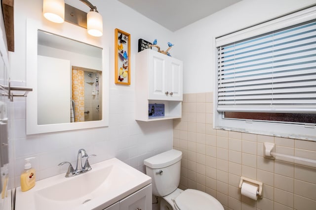 full bathroom featuring toilet, tile walls, vanity, and a tile shower
