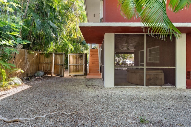 view of yard featuring a sunroom and ceiling fan