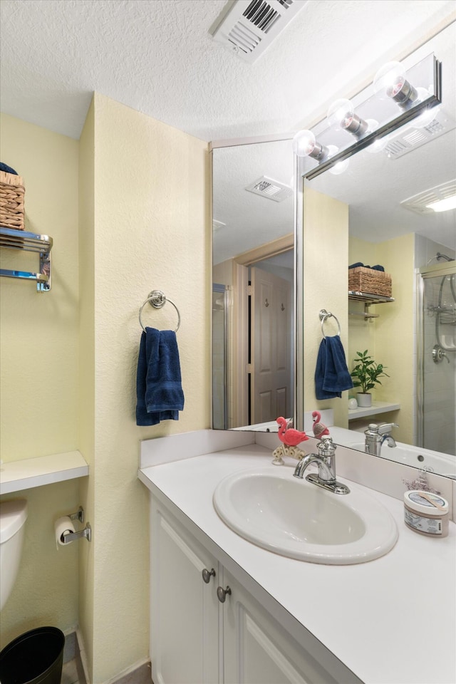64 Seaside N Ct, Key West, FL 33040 - bathroom featuring a shower stall, vanity, toilet, and a textured ceiling