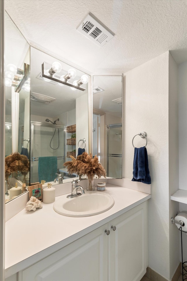 64 Seaside N Ct, Key West, FL 33040 - bathroom with vanity, a stall shower, and a textured ceiling
