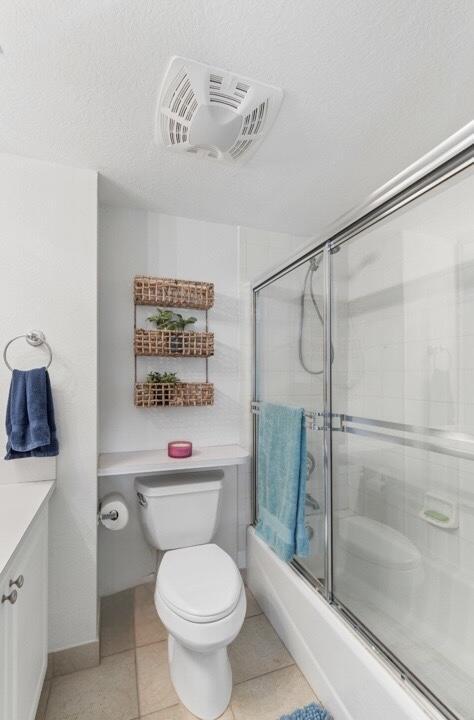 64 Seaside N Ct, Key West, FL 33040 - full bath featuring toilet, vanity, bath / shower combo with glass door, and tile patterned floors