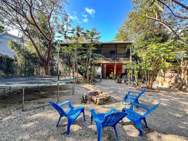 view of yard with a trampoline and an outdoor fire pit