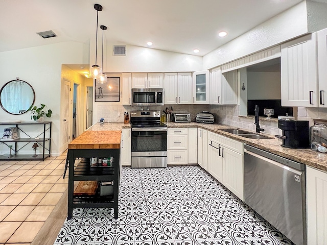 kitchen featuring sink, light stone countertops, white cabinets, and appliances with stainless steel finishes