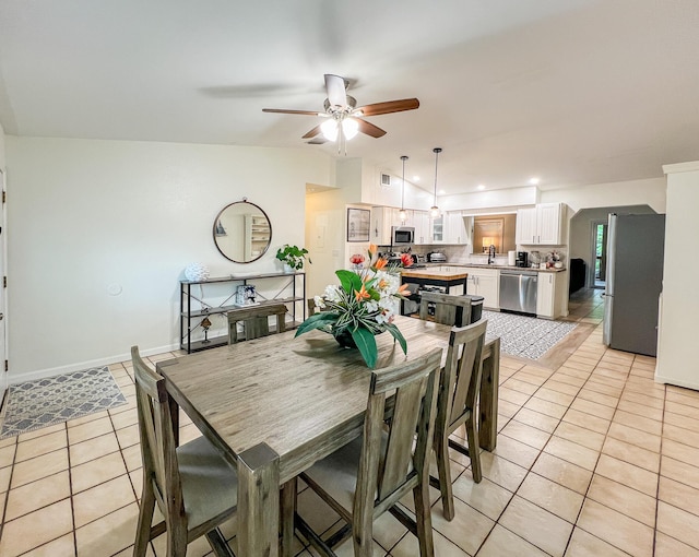 tiled dining room featuring sink, vaulted ceiling, and ceiling fan