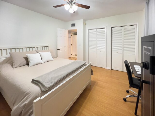 bedroom with multiple closets, ceiling fan, and light wood-type flooring