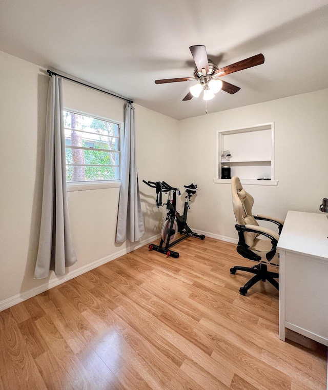 home office with light hardwood / wood-style floors and ceiling fan