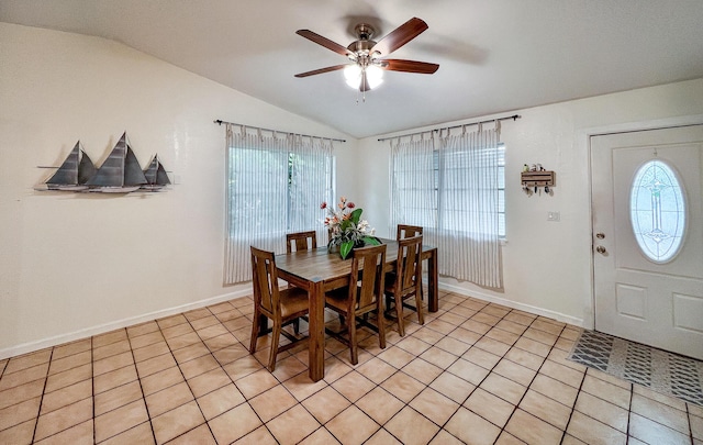 tiled dining area featuring ceiling fan, a healthy amount of sunlight, and vaulted ceiling